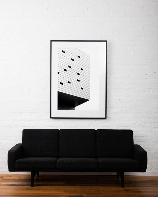 Large vertical Black and White Abstract photo of a bluiding in Urban Europe farmed in black timber on wall above sofa