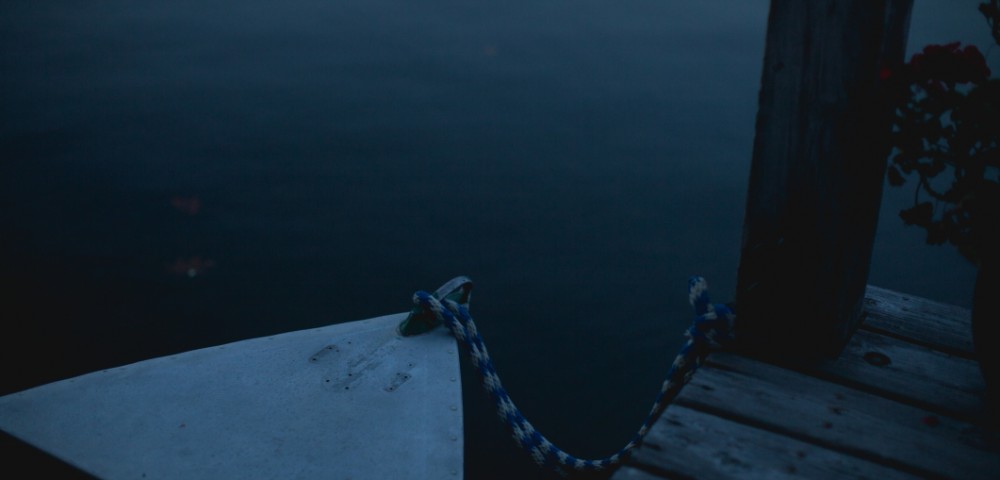 A horizontal Landscape photo of a boat tied to jetty.