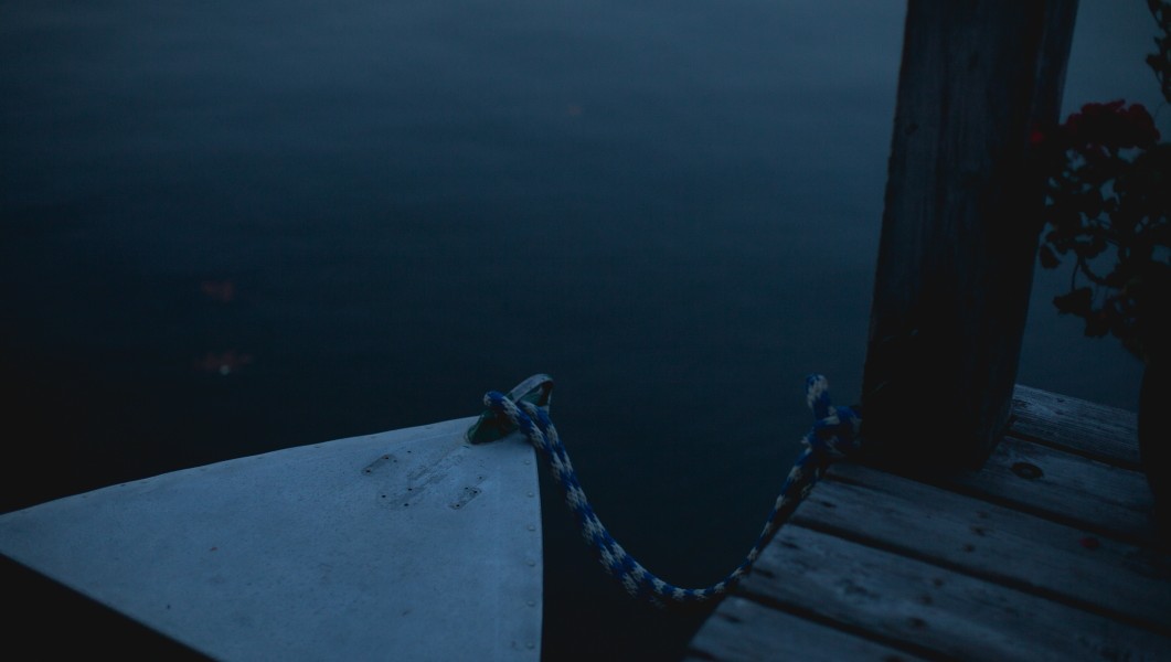 A horizontal Landscape photo of a boat tied to jetty.