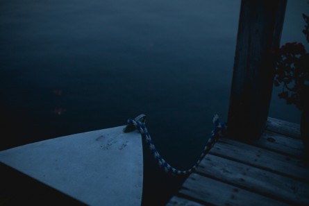 A horizontal Landscape photo of a boat tied to jetty.