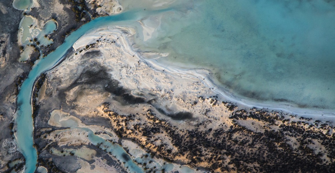 A horizontal abstract aerial photo of water taken in Australia in colour of blue, green and grey