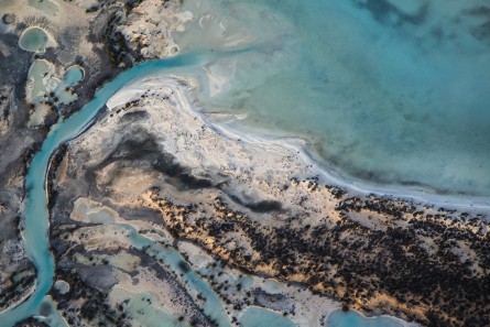 A horizontal abstract aerial photo of water taken in Australia in colour of blue, green and grey