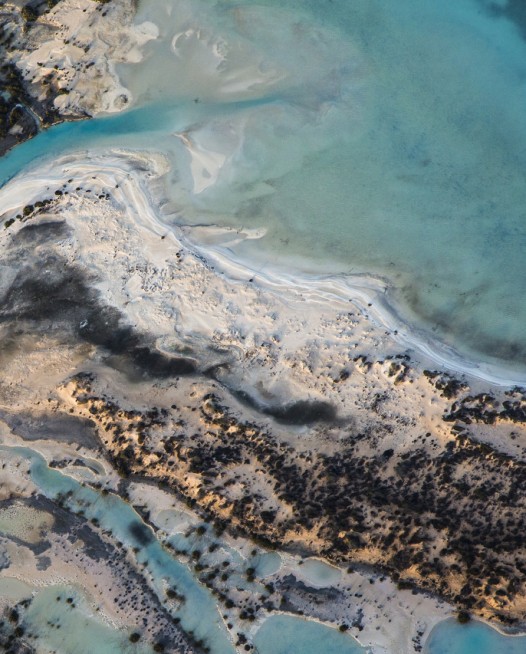 A horizontal abstract aerial photo of water taken in Australia in colour of blue, green and grey