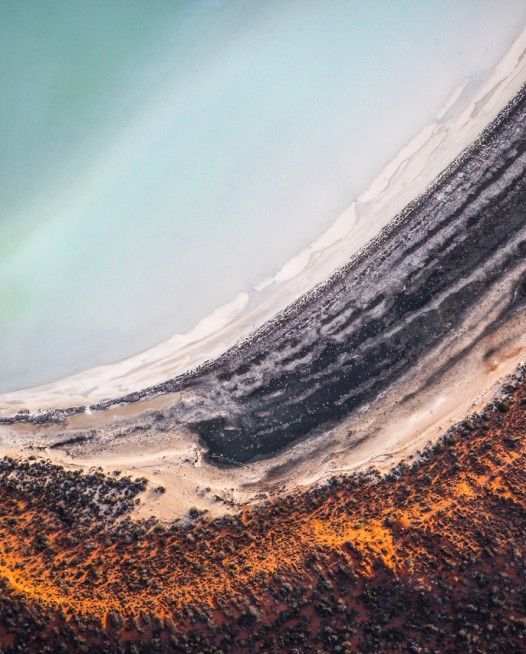 A horizontal abstract, aerial photo of sand and water in Australian Landscape in Orange, blue and brown.