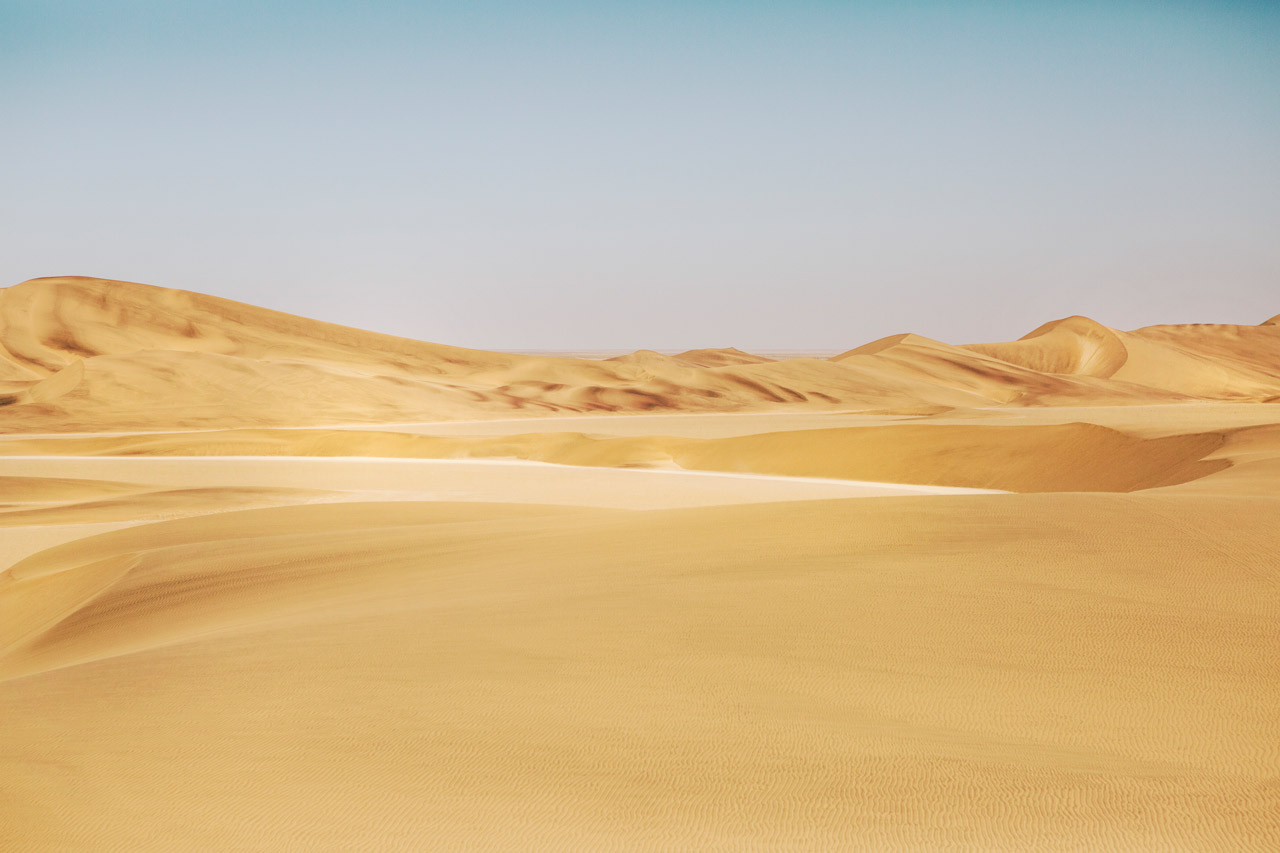 A photograph of Africa desert in yellow sand and blue sky