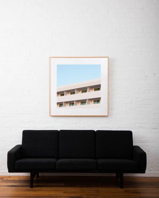 Architectural building taken by Eizabeth Bull in Central American Urban Landscape captured in Pink and Blue tone in a Modernism Art Print framed inraw timber square frame on white wall above sofa