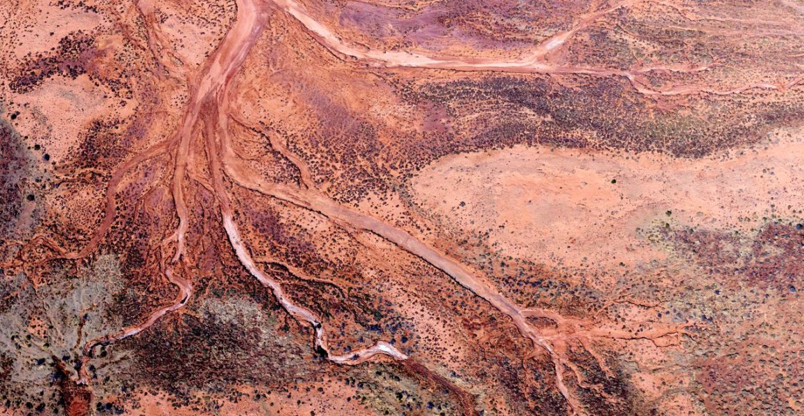 Red and pink aerial photo of the Western Australian landscape.