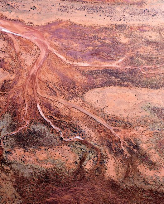 Red and pink aerial photo of the Western Australian landscape.