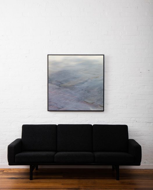 Aerial landscape photo of inland Australia in grey pink blue colours framed in black timber above sofa