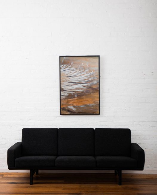 An aerial landscape photo of Australia in brown yellow and silvery colour framed in black timber above sofa